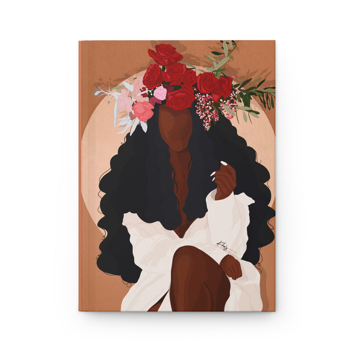 A matte hardcover journal with a cover illustration of a woman with a floral headdress and a dress, sitting in a contemplative pose.