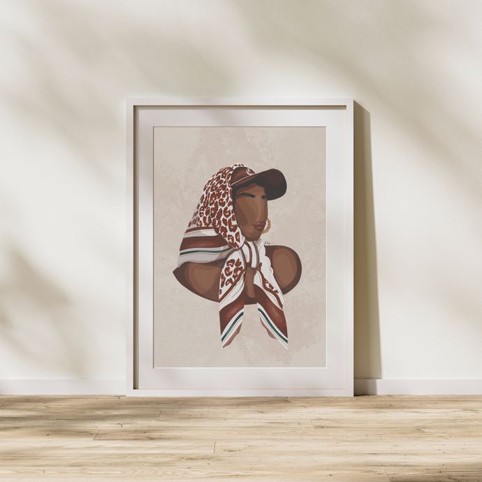 A framed poster featuring a stylized illustration of a woman with a scarf in brown and white tones, displayed on a wall with a shadow on the floor.